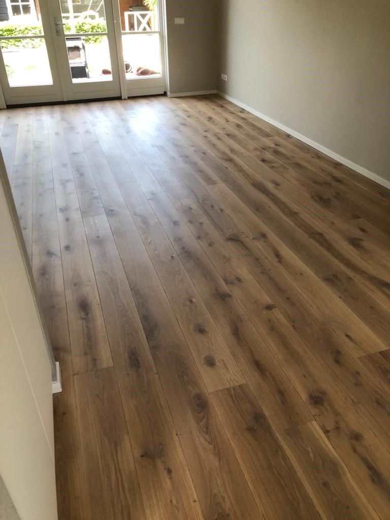 Donker eiken vloer wordt lichter van kleur door parketrenovatie schuren van de vloer.jpg