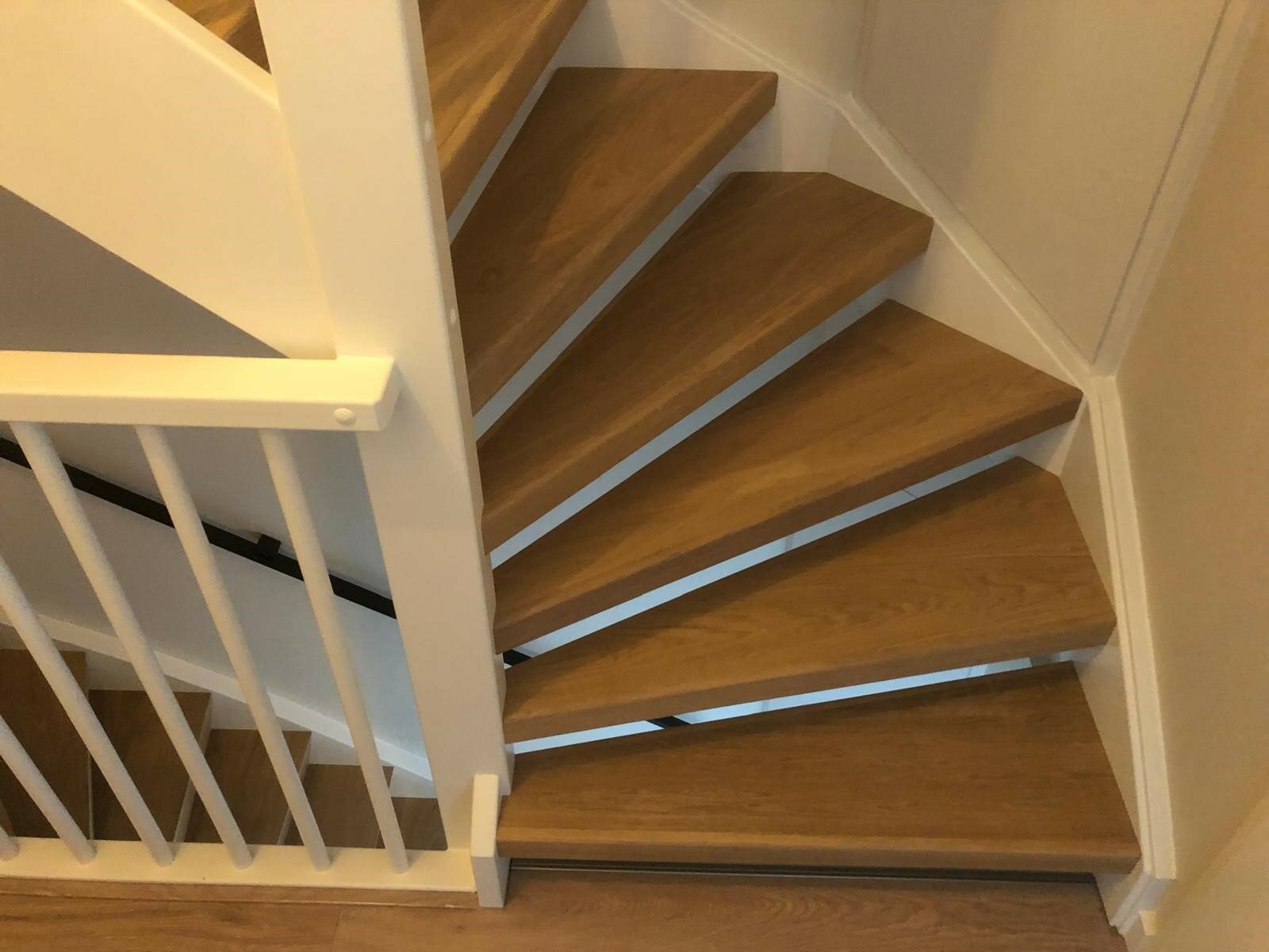 Eiken traprenovatie in zelfde kleur als de vloer eiken rondom eiken Z-overzettreden met stalen leuning Tilburg.jpg