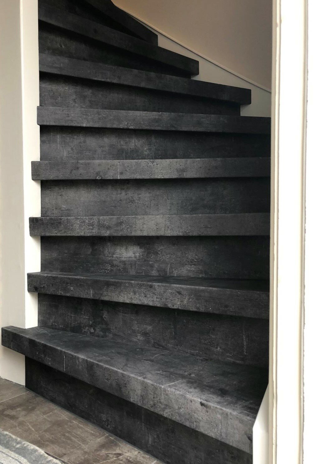 Betonlook traprenovatie vinyl overzettreden en stootborden witte zijwang trapwang trapboom Zaltbommel Den Bosch.jpg