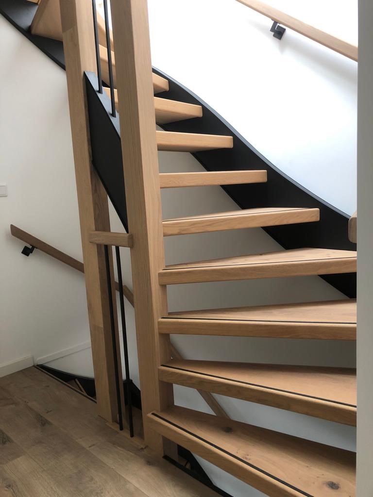 Volledige traprenovatie door plaatsen van eiken overzettreden, zwarte zijwangen, vierkante spijlen en eiken leuningen. Open trap rondom bekleden met eiken..jpg