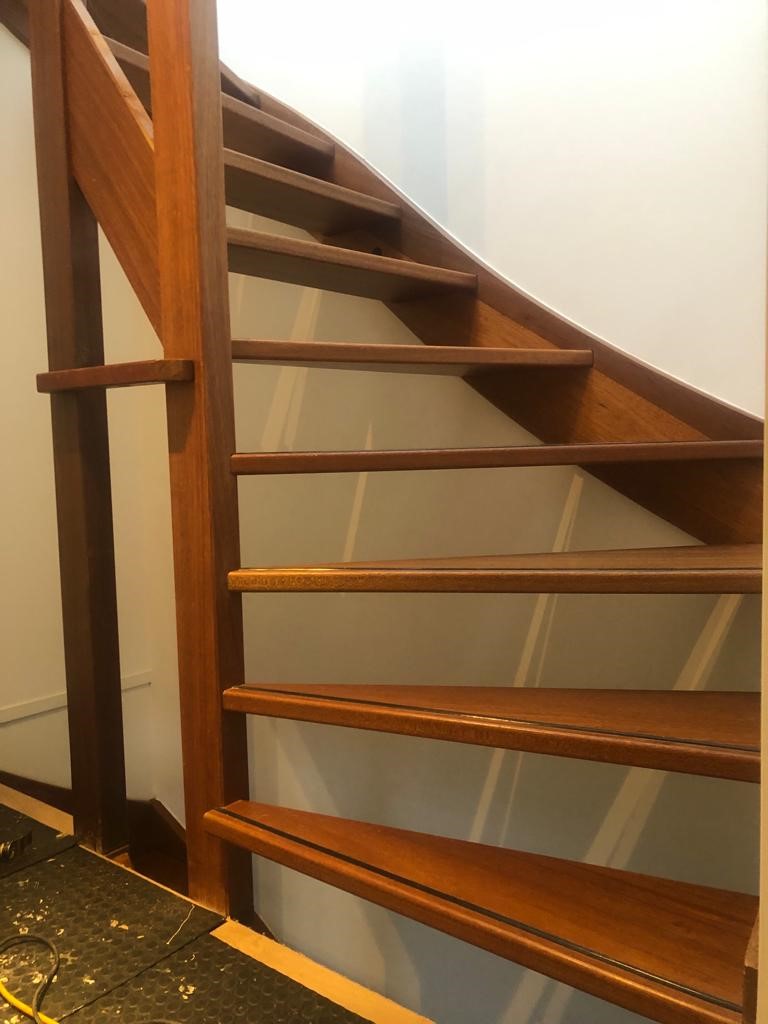 Hardhouten trap wordt eiken trap met zwarte zijwangen en moderne balustrades.jpg