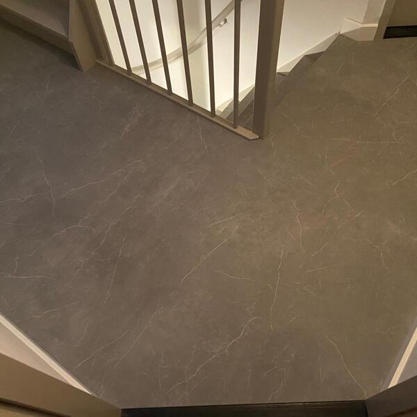 Marmerlook vloer op overloop bij traprenovatie.JPG