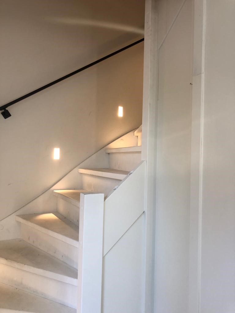 Eiken Z-trap door overzettreden naturel geolied met witte zijwangen stalen leuningen balustrade muurtje.jpg