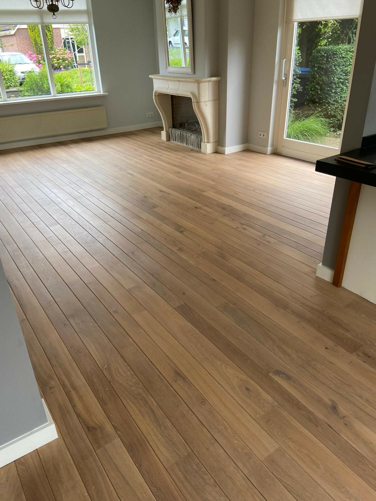 Verkleurd eiken schuren en opnieuw oliën met 2-componenten olie Monocoat Smoke 5% witte plinten Zaltbommel vloer schuren.jpg