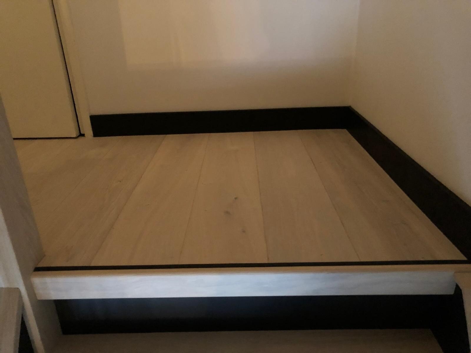 Eikenhouten traprenovatie landelijk interieur met eiken vloer op overloop zwart met whitewash nieuwe balustrade maatwerk.jpg