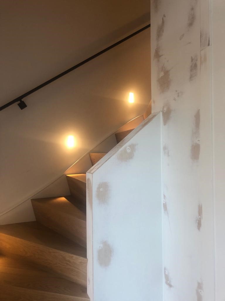 Eiken Z-traprenovatie met witte zijwangen en stalen leuningen Den Bosch.jpg