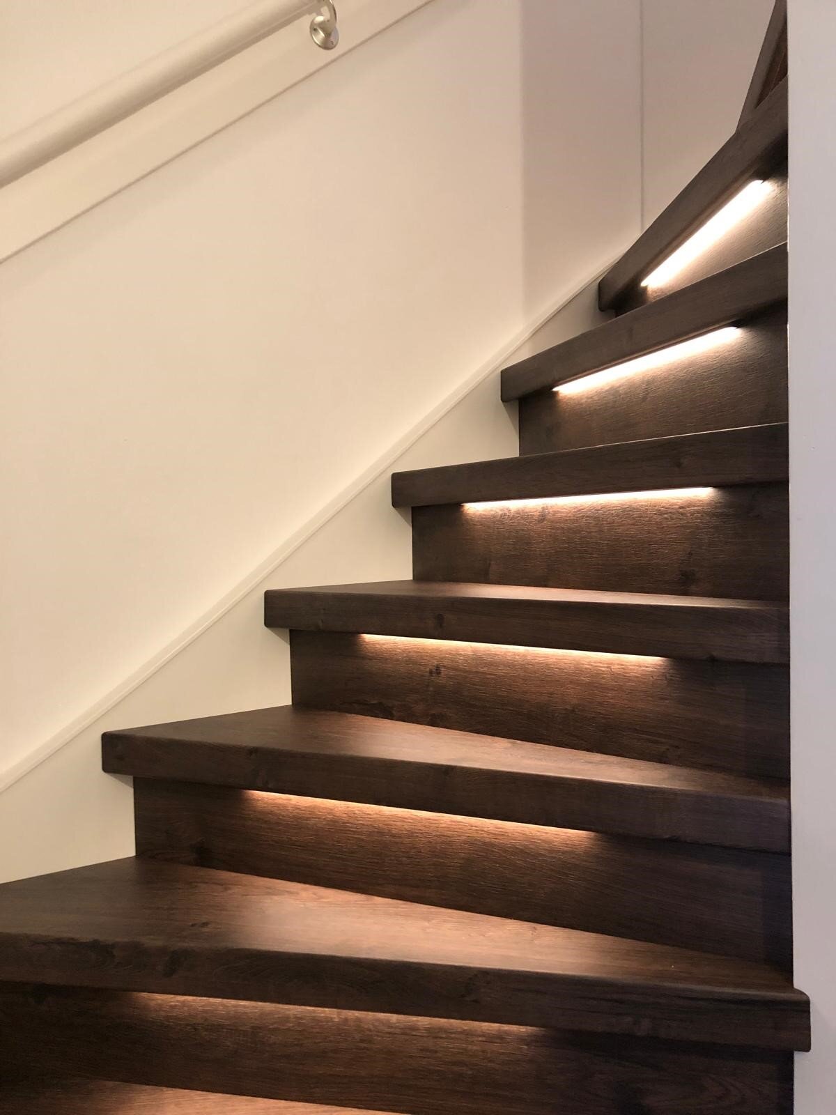 Laminaat traprenovatie, HPL overzettreden, notenhout, houtlook, donkerbruin, modern met LED verlichting bewegingssensor.jpg