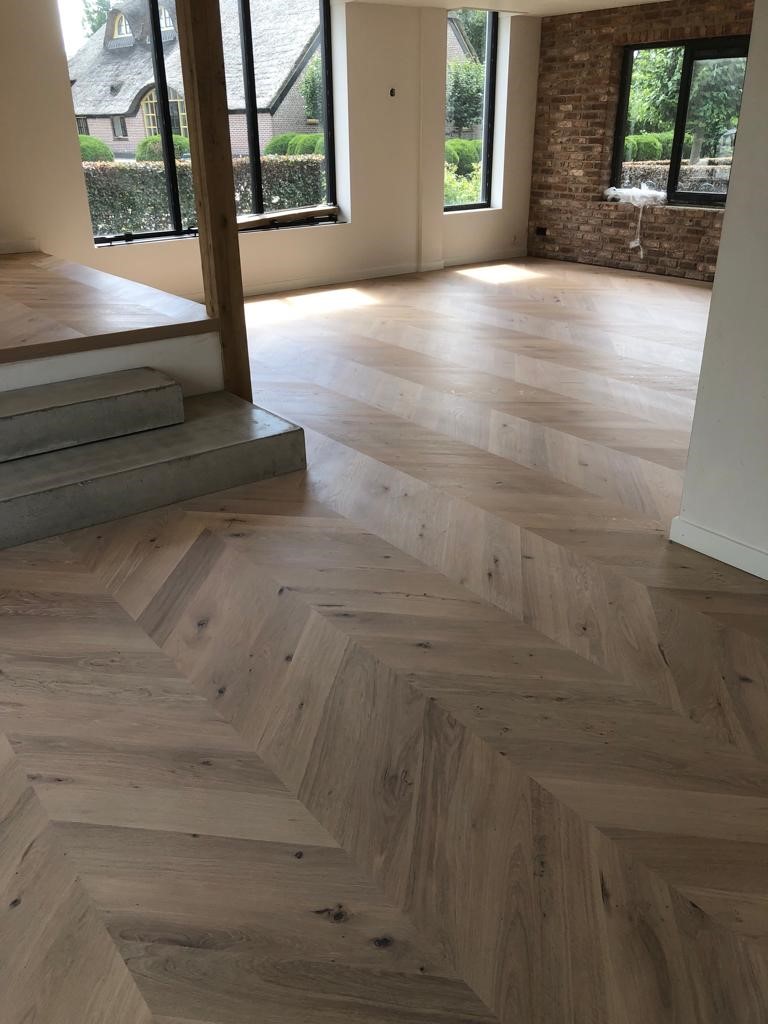 Eiken Hongaarse punt visgraat vloer met witte plinten icm betonnen vloer naturel eiken nieuw.jpg